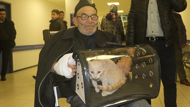 man hugs cat after house fire