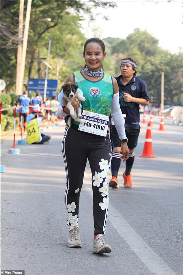 marathon runner carries dog